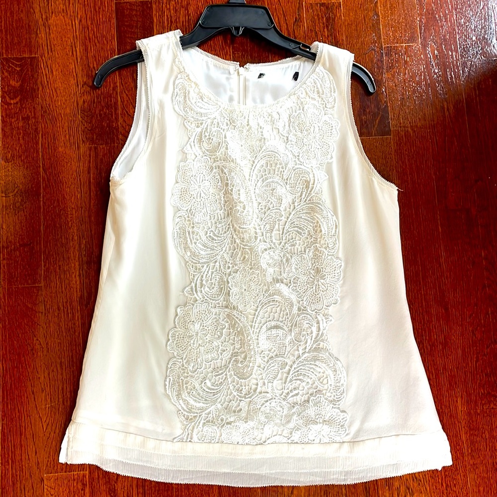 Ivory sleeveless silk top with lace trim and sheer edging at shoulder and hem.